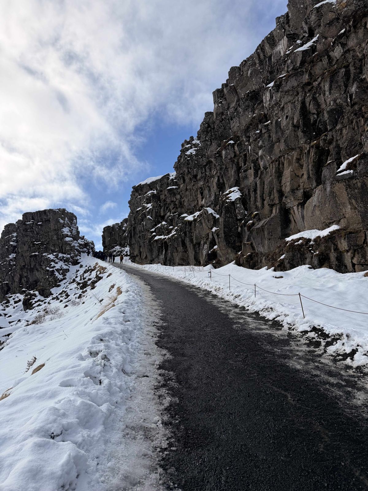 Almannagjá gorge — walking the path between basalt walls, snow on both sides