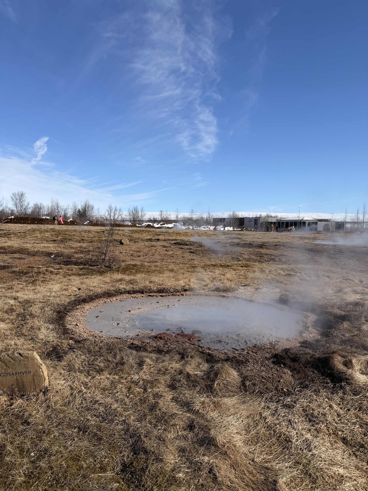 Geysir hot spring — steaming pool, blue sky, dry golden grass