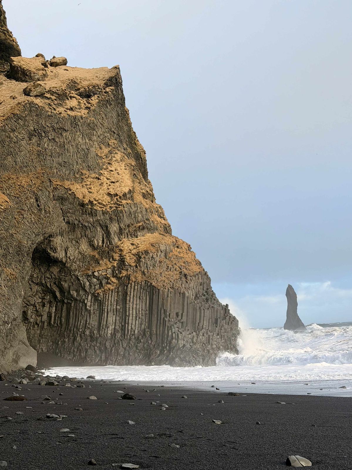 Reynisfjara — towering basalt columns, lone sea stack in the distance