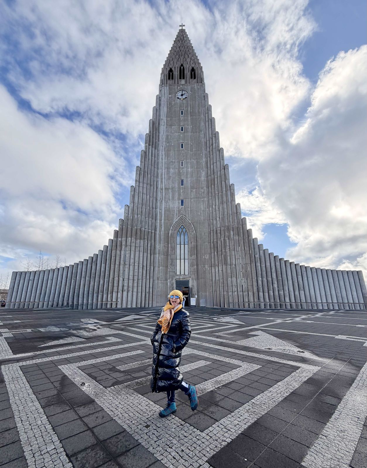 Sucheta at Hallgrímskirkja — yellow hat, blue sunglasses, big smile
