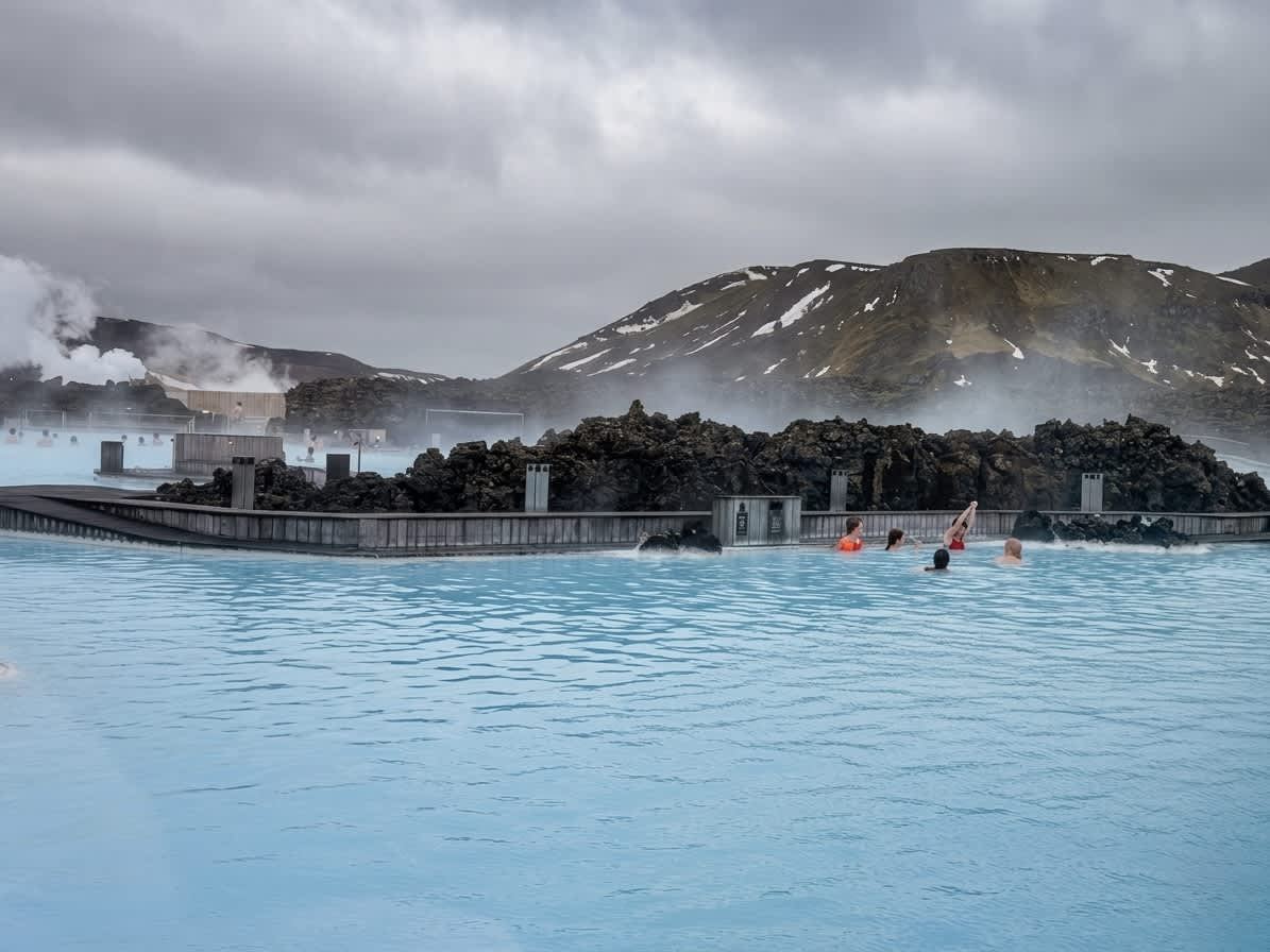 Blue Lagoon — milky blue geothermal water, steam rising, dark lava rocks
