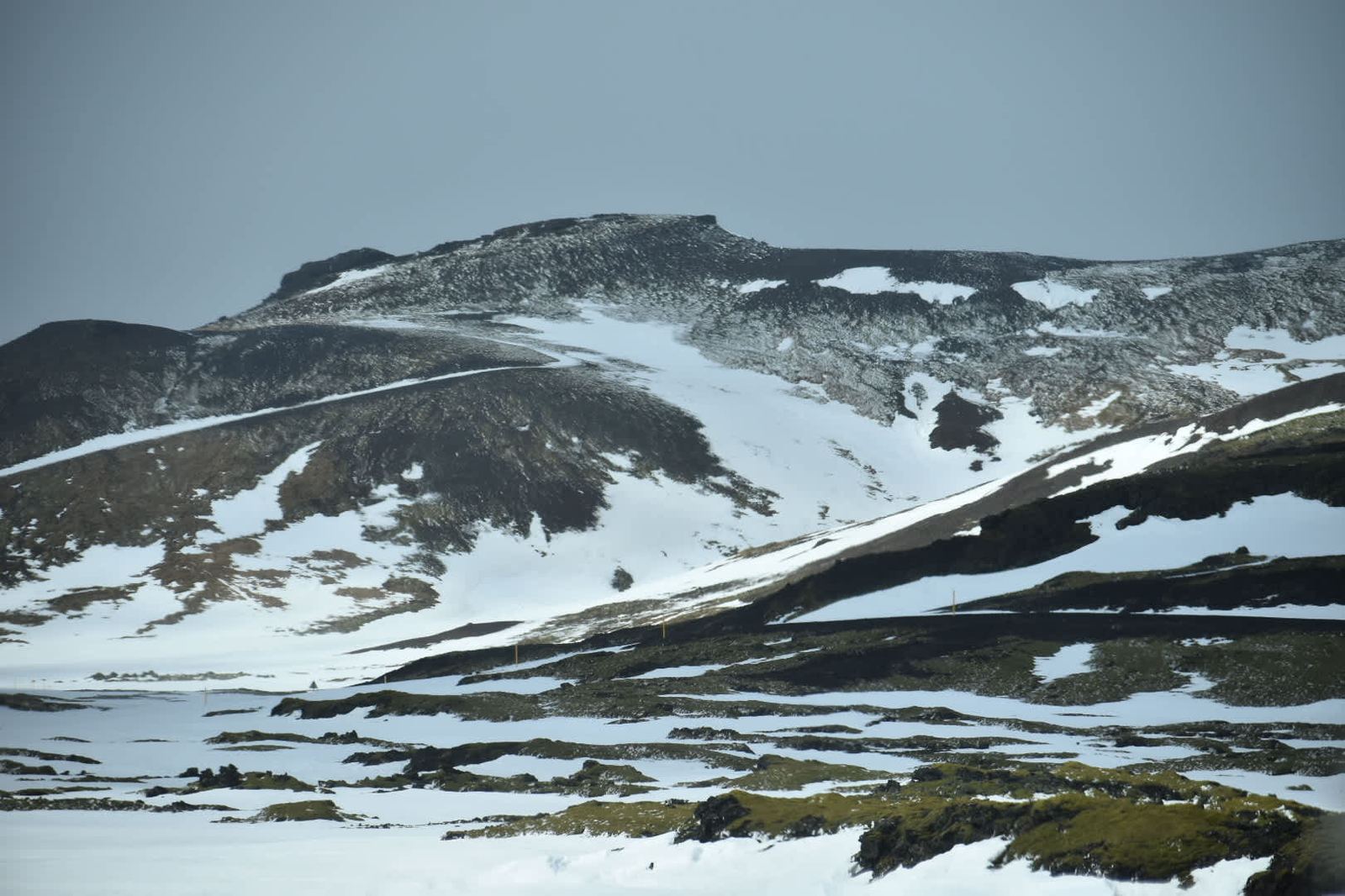 Snow and lava landscape near Reykjavik — dark volcanic rock through white